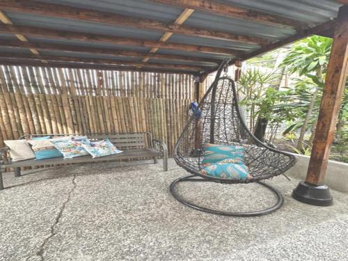 a porch with a hammock and a bench on a patio at Nappers Hostel in Cebu City