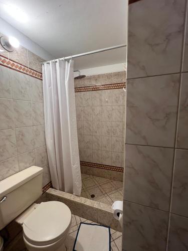 a small bathroom with a toilet and a shower at Yanapanakusun Cusco in Cusco
