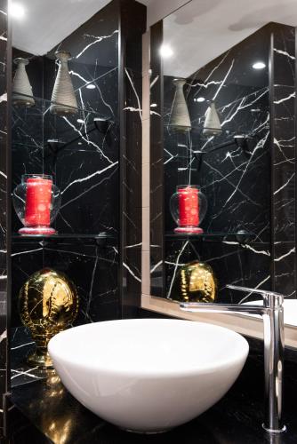 a bathroom with a white sink and red candles at Lovely Colosseum loft apartment in Rome