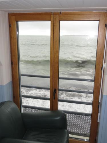 a view of the ocean through a sliding glass door at Hôtel Kermor in Concarneau