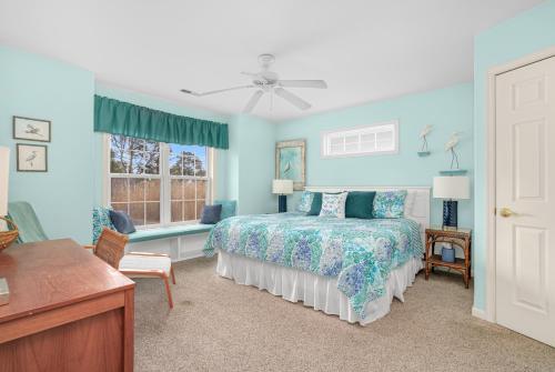 a blue bedroom with a bed and a window at Seas the Day - Water views, Shared pool! in Chincoteague