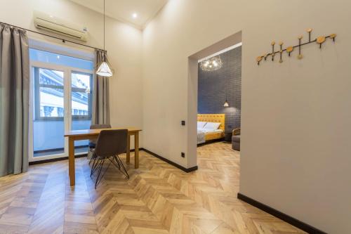 a dining room with a table and a bedroom at Idea Design Apart-Hotel Prorizna in Kyiv