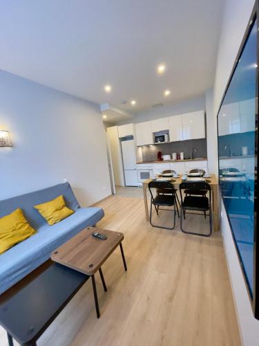 un salon avec un canapé bleu et une table dans l'établissement Appart'Village Le vieux Vichy centre T1,T2,T3 - Parking - Thermes, à Vichy