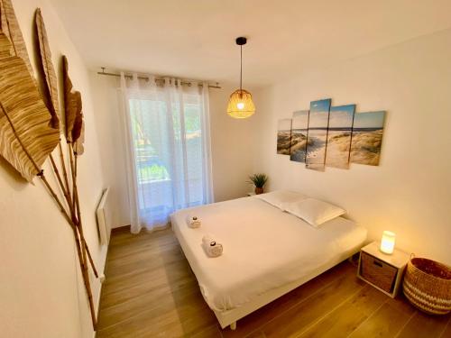 une chambre avec un lit blanc et une fenêtre dans l'établissement PGH N10-Terrasse, Parking Privé, 500m de la Plage, à La Grande Motte