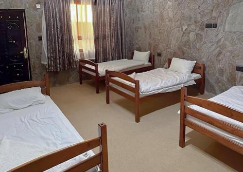 a room with three beds and two chairs at bait bimah travel lodge in Bīmah