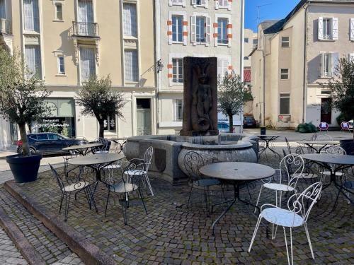 un gruppo di tavoli e sedie di fronte a una fontana di Appart'Village Le vieux Vichy centre T1,T2,T3 - Parking - Thermes a Vichy