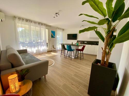 un salon avec un canapé et une plante en pot dans l'établissement PGH N10-Terrasse, Parking Privé, 500m de la Plage, à La Grande Motte
