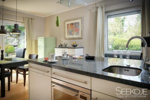 a kitchen with a sink and a counter top at Seekoje - Haus Am Möhnesee in Möhnesee