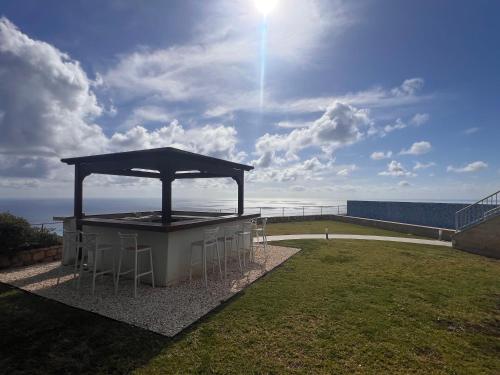 a pavilion with chairs and the ocean in the background at Matteo Villa Limassol Cyprus in Limassol