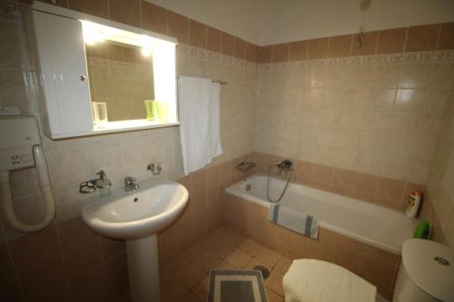 a bathroom with a sink and a bath tub at Zorbas studio deluxe in Moraitika