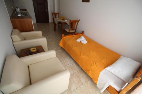 a bedroom with a bed and a couch and a table at Zorbas studio deluxe in Moraitika