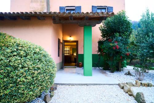 an entrance to a pink house with a green column at Locanda Borgo Colmello in Villanova di Farra