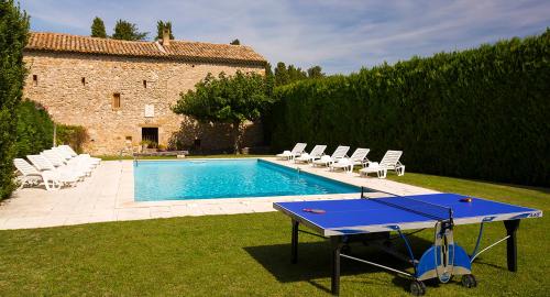 - une table de ping-pong dans une cour à côté d'une piscine dans l'établissement Maison d'Hôtes Lou Geneste, à Bollène