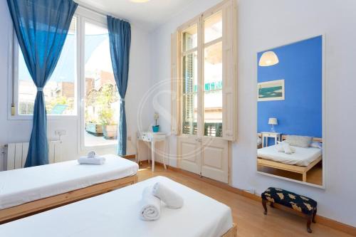 une chambre avec deux lits et un miroir dans l'établissement Apartamento con Terraza en Poble Sec, à Barcelone