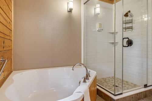 a bathroom with a tub and a glass shower at Red Wolf by Carolina Mornings in Fletcher