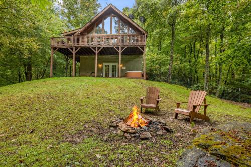 a fire pit with two chairs in front of a house at Red Wolf by Carolina Mornings in Fletcher