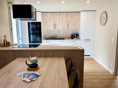 une cuisine avec un comptoir en bois et une table en bois dans l'établissement 'La Perrière' Joli T2 en duplex Clim, Wifi, à Sète