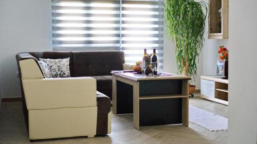 a living room with a couch and a table with wine bottles at Apartments Pravica Trebinje in Trebinje