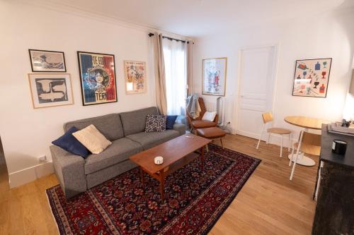 un salon avec un canapé et une table dans l'établissement Minimalist Haussmannian Paris 11, à Paris