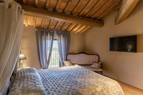 a bedroom with a bed and a window at Agriturismo Poggio Il Castellare in Montalcino