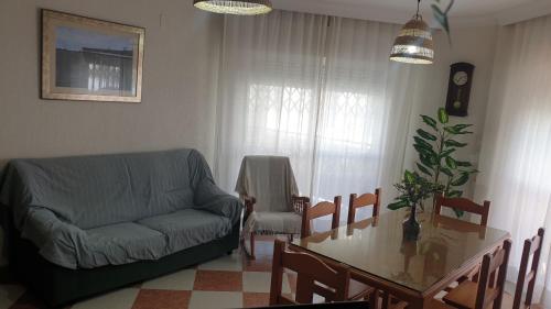 a living room with a couch and a dining room table at Casa Delfin in Punta Umbría