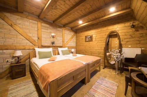 a bedroom with a bed in a wooden room at Ethno Houses Plitvice Lakes Hotel in Plitvica selo
