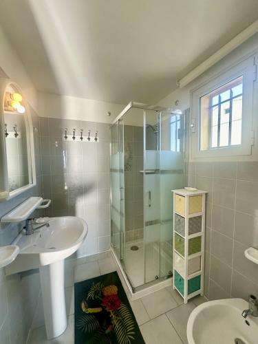 une salle de bain avec deux lavabos et une douche en verre dans l'établissement Appartement vue mer à Ile Rousse avec parking privé, à LʼÎle-Rousse