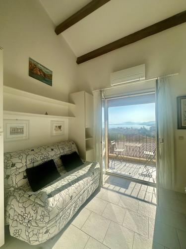 une chambre avec un lit et une porte coulissante en verre dans l'établissement Appartement vue mer à Ile Rousse avec parking privé, à LʼÎle-Rousse