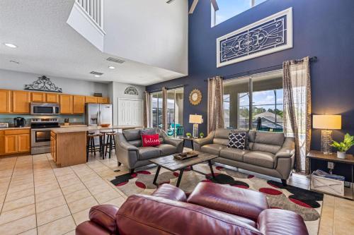 a large living room with couches and a kitchen at 7BDM Prvt Pool Villa - Gated Resort 10min to Disney in Kissimmee