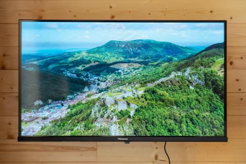 a flat screen tv hanging on a wall at Gite L'insolite dans le Jura in Étival