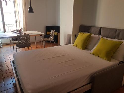 a large bed with two yellow pillows in a room at L'Altana City House in Brescia