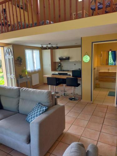 a living room with a couch and a kitchen at Gîte berneval le grand in Berneval-le-Grand