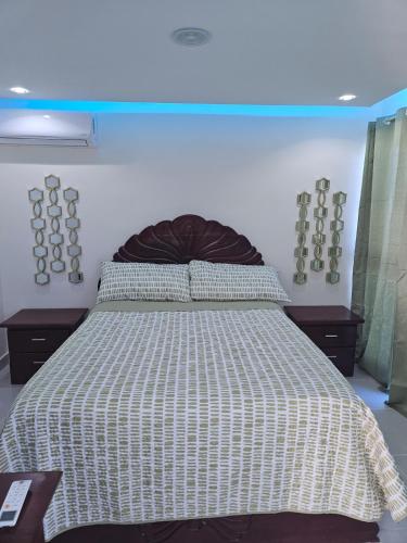 a bedroom with a bed with a white and black comforter at Luxury Studio in San Isidro