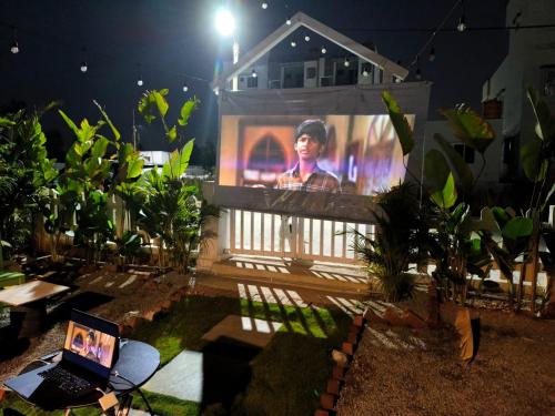 a screen in front of a house with a laptop at Cozy Cottage near Hessarghatta in Bengaluru