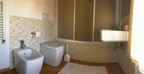 a bathroom with a toilet and a bidet and a sink at La Collina Tuscan stone cottage in Soci