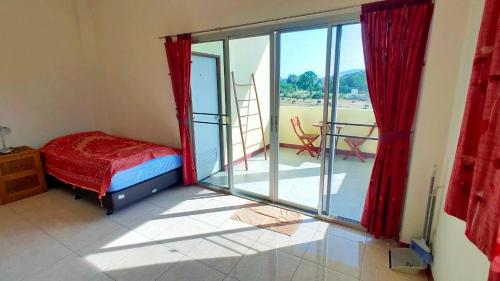 a bedroom with a bed and sliding glass doors at Baan Nokkamin Seaside in Hua Hin - บ้านนกขมิ้นซีไซด์ หัวหิน in Hua Hin
