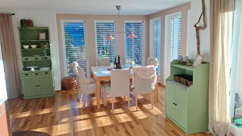 a dining room with a table and white chairs at HomeSlovenia - your Home in the Heart of Slovenia in Selca