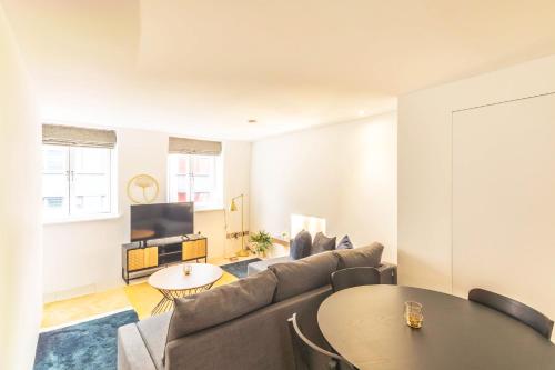 a living room with a couch and a table at Accomodo London Soho - Elegant Apartments near Carnaby Street and Oxford Street in London