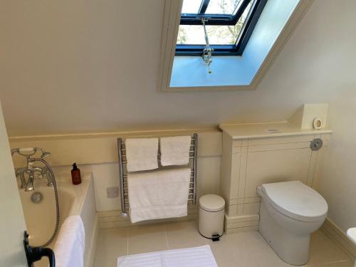 a bathroom with a toilet and a sink and a window at The Barn at Frog Pond Farm in Salisbury