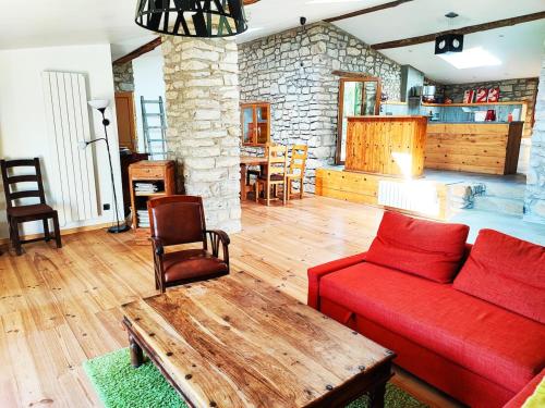 un salon avec un canapé rouge et une table dans l'établissement LA BERGERIE DE CORCONNE, à Corconne