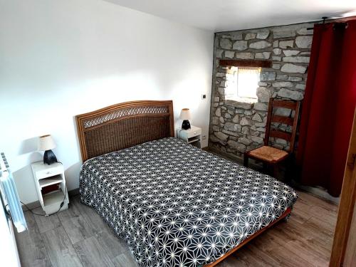 une chambre avec un lit et un mur en pierre dans l'établissement LA BERGERIE DE CORCONNE, à Corconne