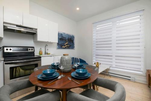 a kitchen with a wooden table with chairs and a dining room at Peaceful 1BR Getaway Near MTL Village in Montréal