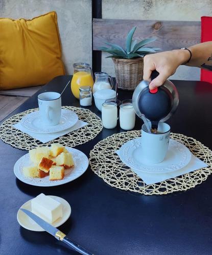 une personne verse du café dans une tasse sur une table dans l'établissement Les cigales, à Hyères
