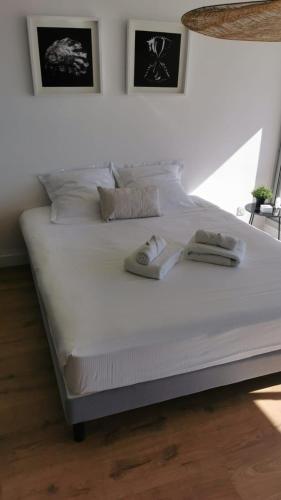 - un grand lit blanc avec 2 serviettes dans l'établissement Azur 2 vue sublime clim, parking, terrasse, Wifi, à Sète