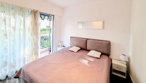 une chambre avec un lit et une fenêtre dans l'établissement Positive, à Cannes