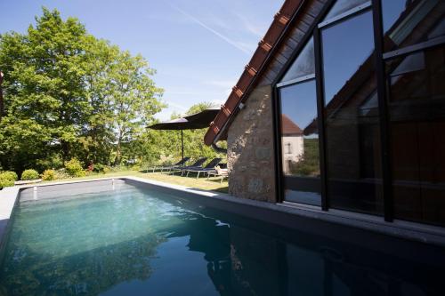 - une piscine à côté d'une maison dans l'établissement Nonpareil, à Peyrat-la-Nonière