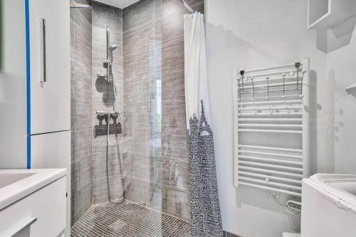 une salle de bain avec une douche avec un rideau de douche dans l'établissement Superb 1BR flat 2min walk from the metro station, à Paris