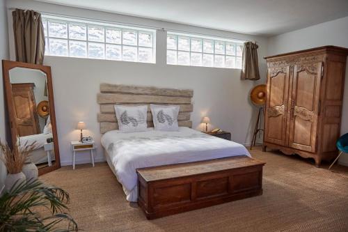 une chambre avec un grand lit et un grand miroir dans l'établissement Maison de Vacances avec piscine en Normandie, à Rugles