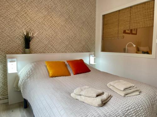 a bedroom with a bed with towels on it at AppartCosy 21 Centre Historique T4 in Vitré