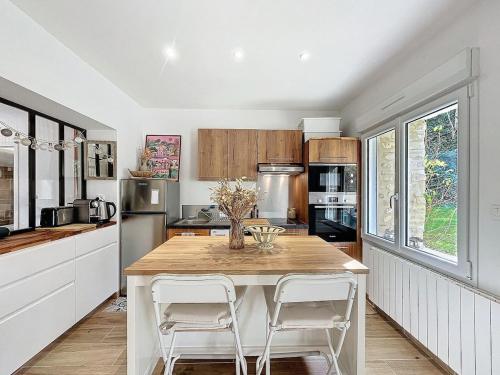 une cuisine avec une table et deux chaises blanches dans l'établissement Cozy garden apartment - Caen, à Caen